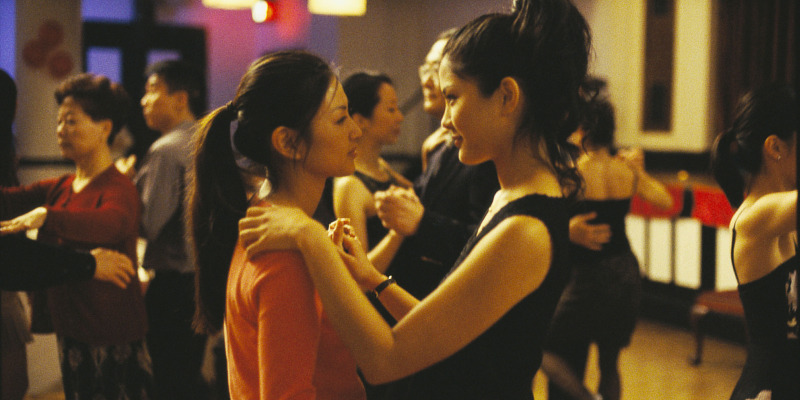 Two women dancing looking into each other's eyes.