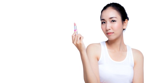 woman in tanktop holding a tube of chapstick
