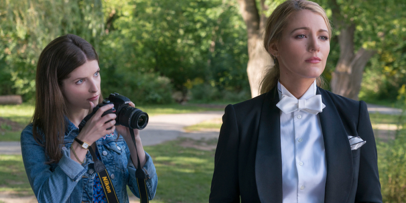 Anna Kendrick holds a camera and looks up at Blake Lively in a tux.