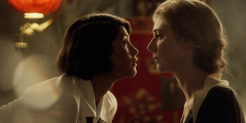 Elizabeth Debicki and Gemma Arterton almost kiss.