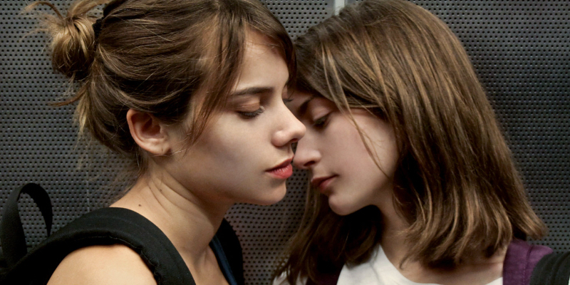 Two girls almost kiss.