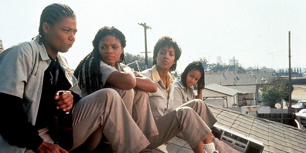 A scene from Set It Off where the four main characters of set it off sitting on a roof overlooking a factory