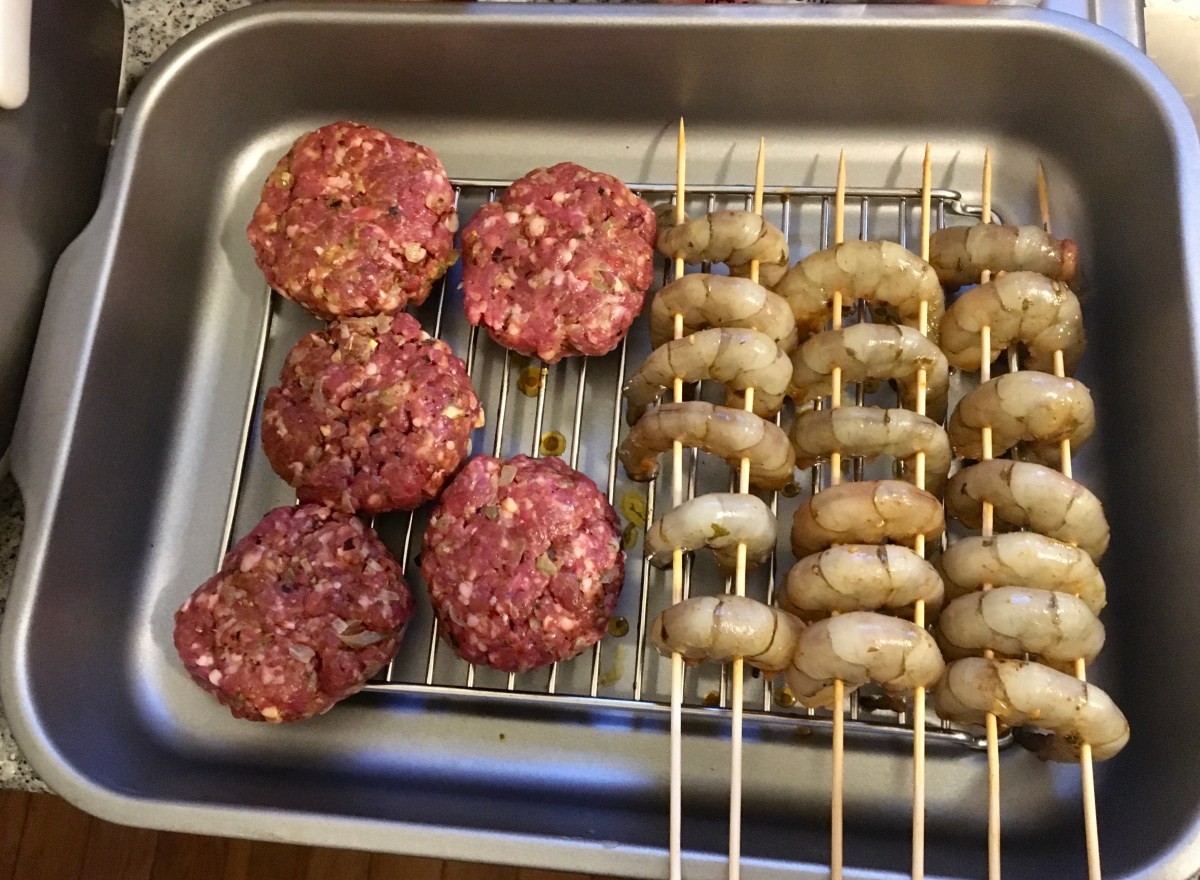 lamb patties and shrimp skewers on a tray ready to be grilled