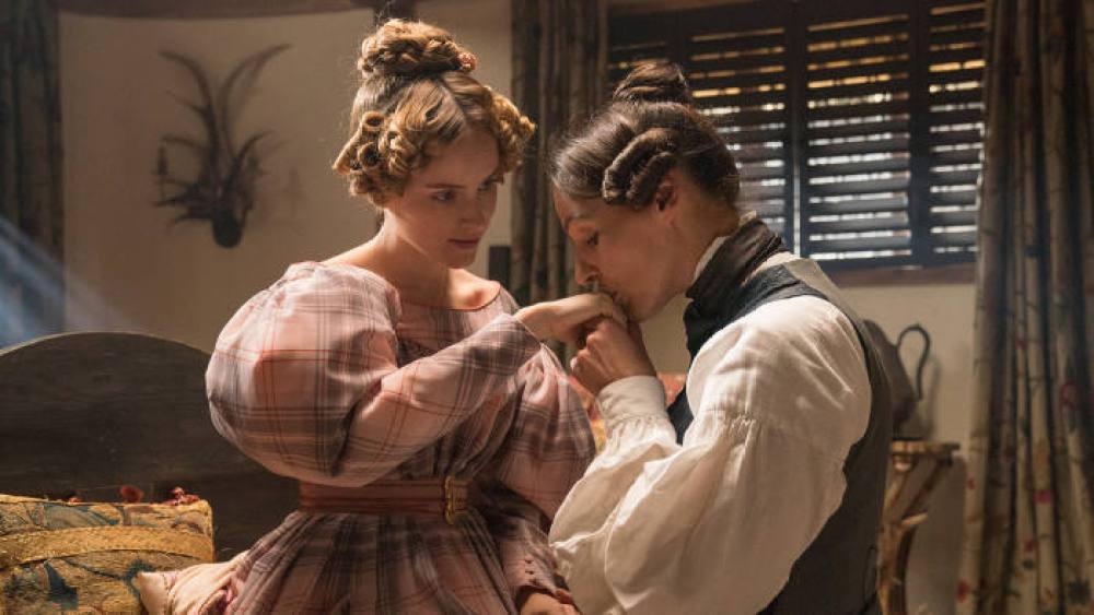 Anne Lister kisses her girlfriend Anne on her hand in period costumes. Still from "Gentleman Jack" on HBO