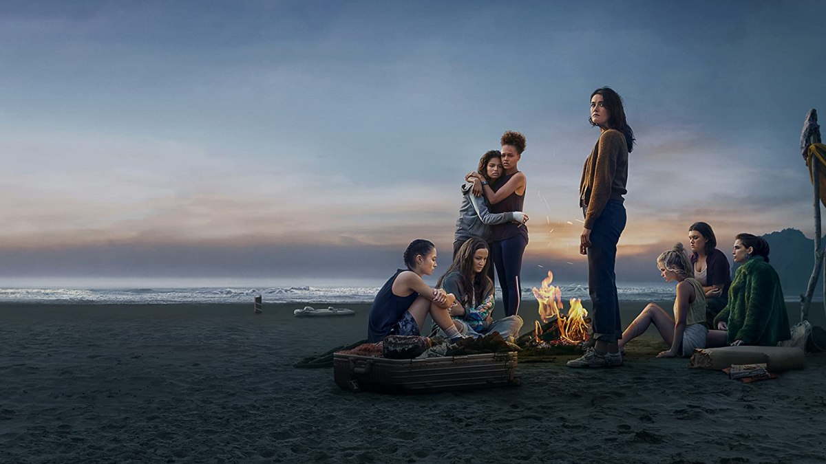 eight teenage girls stranded on an island looking miserably towards the sunset in "The Wilds"