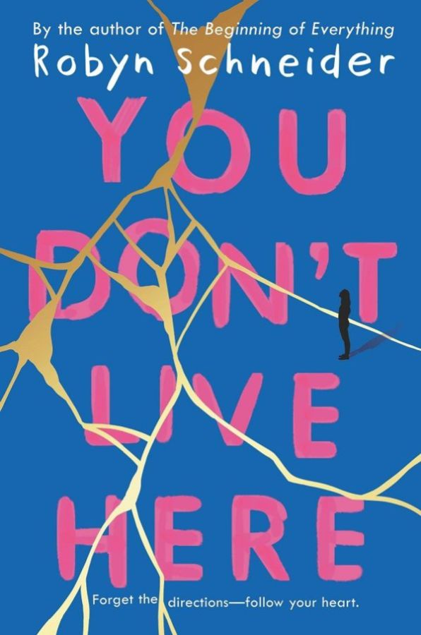 The cover for "You Don't Live Here" is ripped up and put back together like a strewn blue piece of paper being held together with gold tape. The book's title is pink ink, as if it was painted on the tapped up blue paper with a brush.