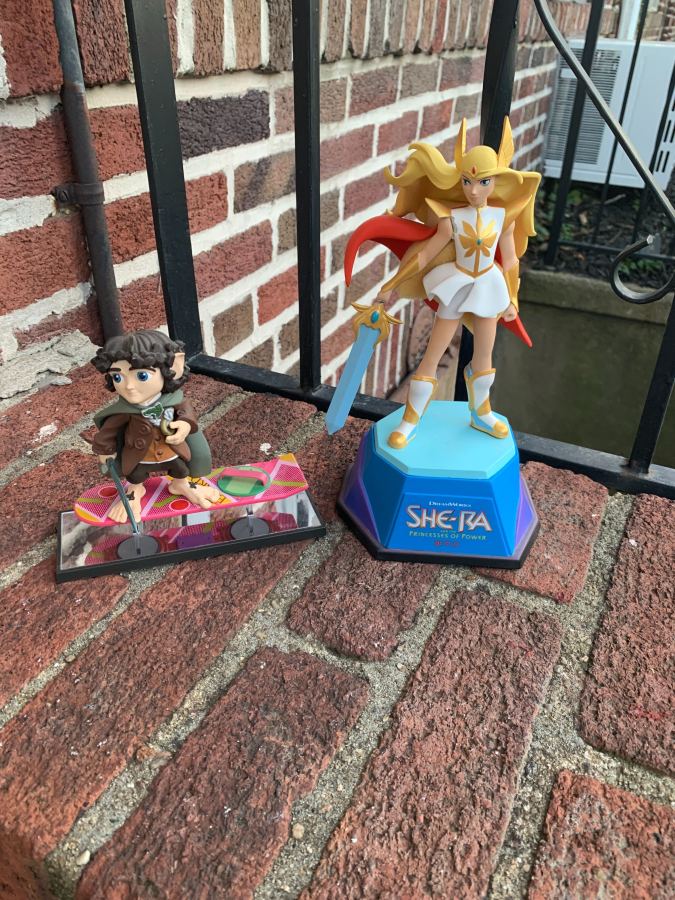 figurines of She-Ra and Frodo, also on a brick stoop