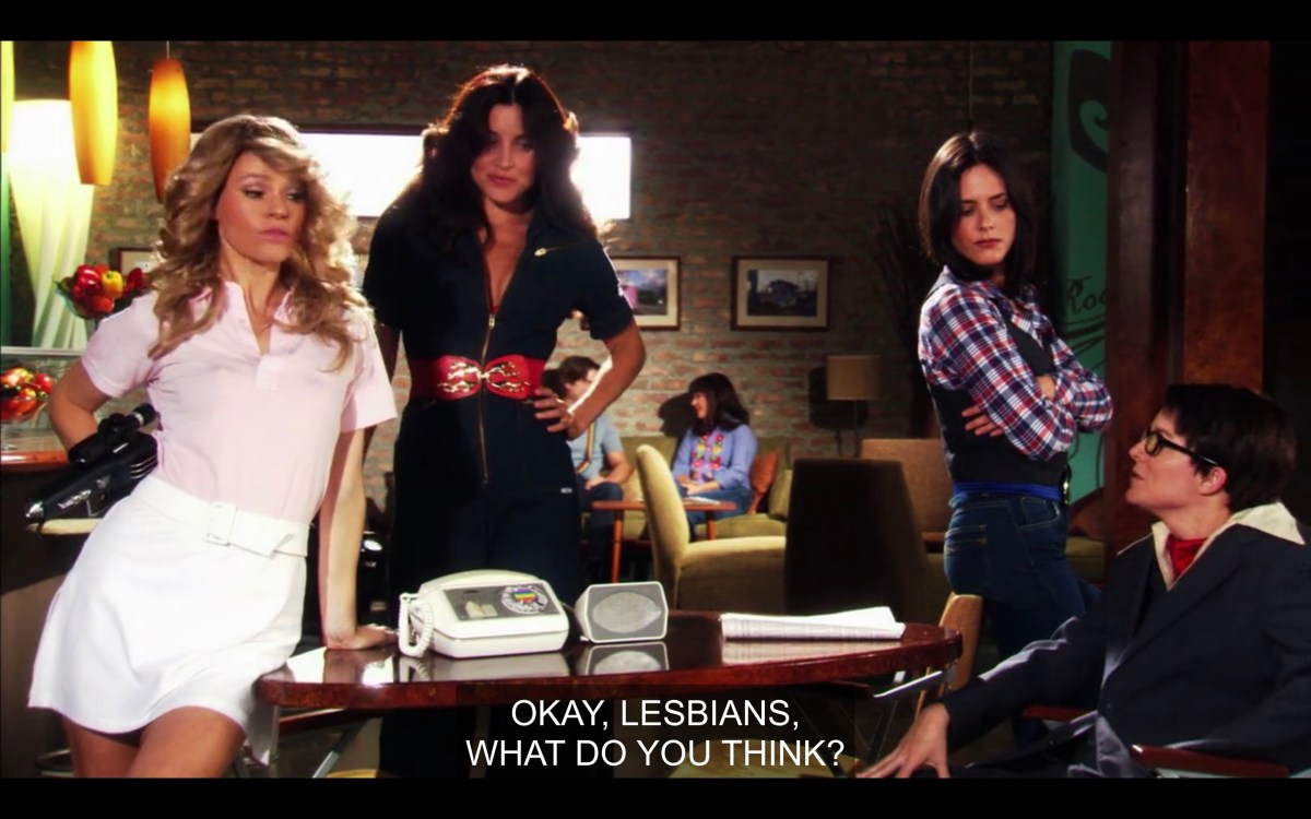 Alice, Helena and Shane dressed in 70s outfits as Charlie's Angels. Tina in an oversized suit. Caption says "Okay Lesbians, What Do You Think?"
