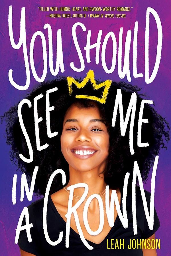 The "You Should See Me in a Crown" cover is bright purple and fuchsia. There's a teenage Black girl with a big afro smiling in the middle. She has a graffiti yellow crown drawn delicately upon her head.