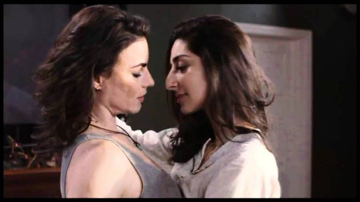 Screencap from lesbian movie Elena Undone in which two women embrace, their bodies pressed together and their eyes hanging low. This is a lesbian movie available for streaming on Hulu.