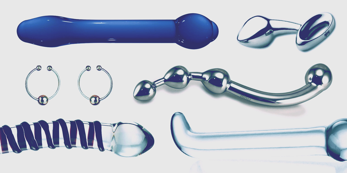 A collage of sex toys, including an array of glass dildos, nipple rings, a stainless steel wand toy and a stainless steel butt plug, all edited with a cool blue cast