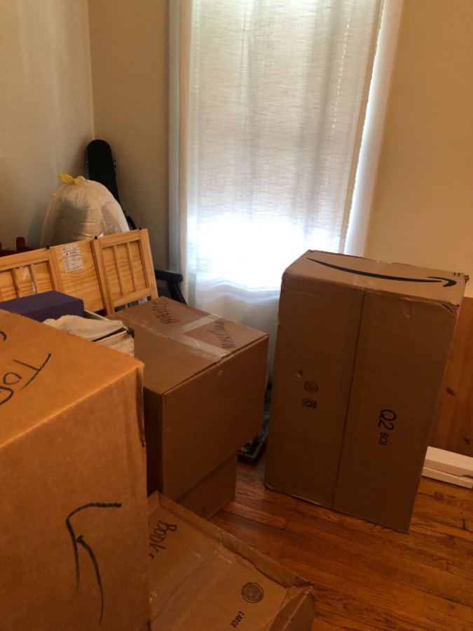 A photograph of moving boxes stacked high in a New York apartment