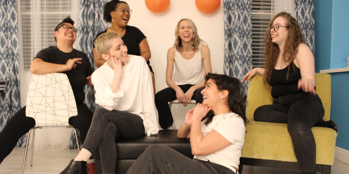 The team shares a giggle together. From left to right, Kamala, Laneia, Carmen, Riese, Sarah and Rachel all wear pretty darn happy expressions.