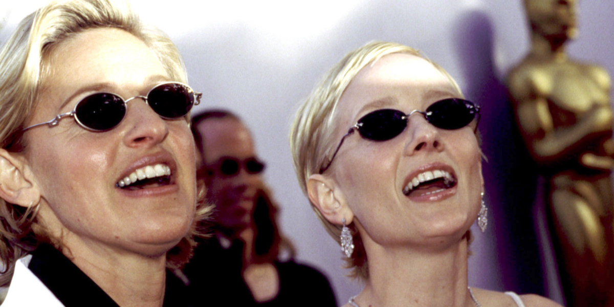 Anne Heche and Ellen DeGeneres standing together on a red carpet in 1997.