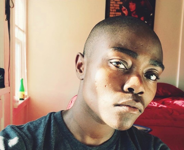 a photo of the author's face, his bald Black head, watchful brown eyes, thick eyebrows, and slightly pursed mouth