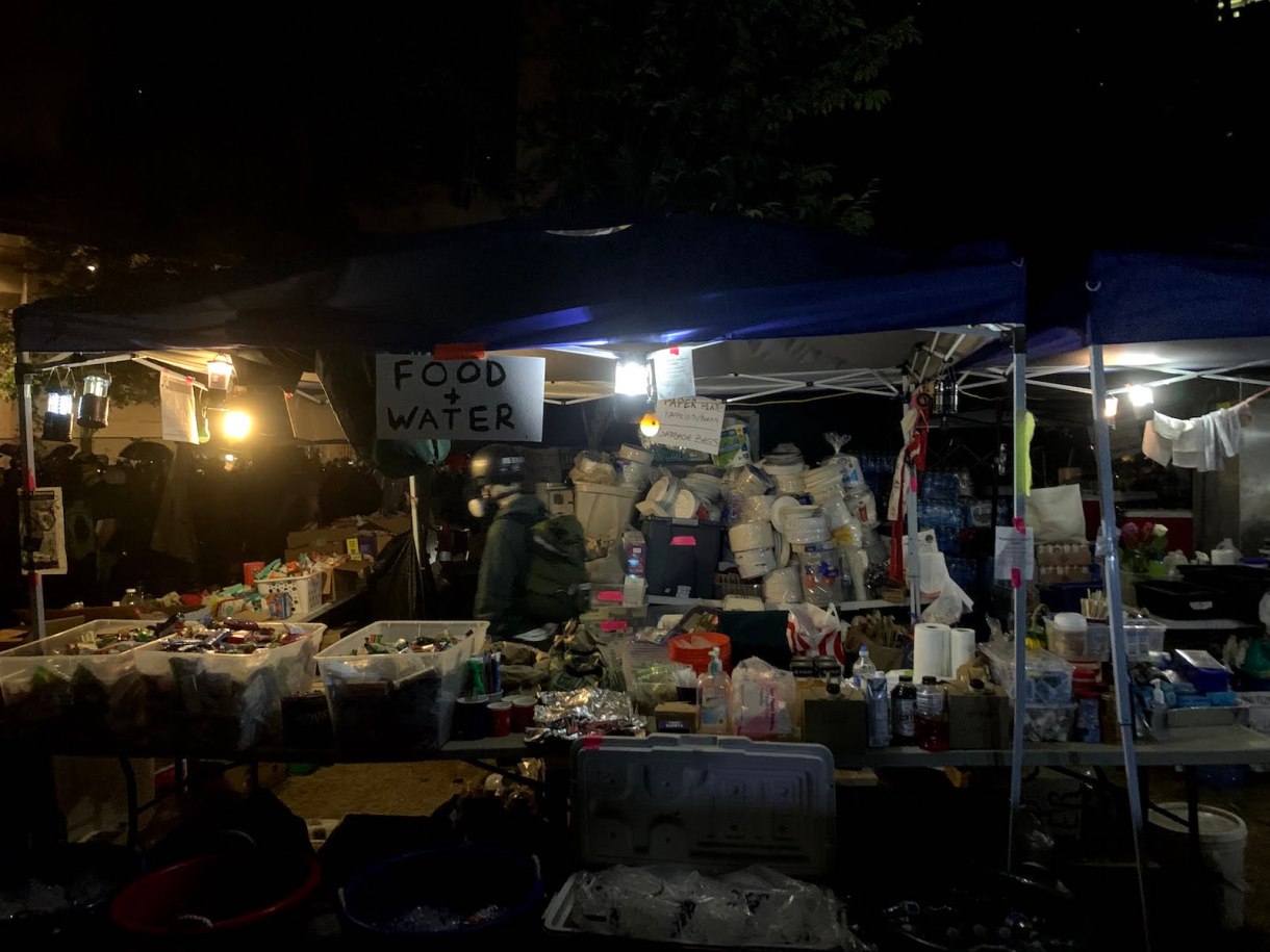 A mountain of donated food, water, and other supplies at Riot Ribs, a free, volunteer-run outdoor kitchen that fed protesters and community members throughout July. 