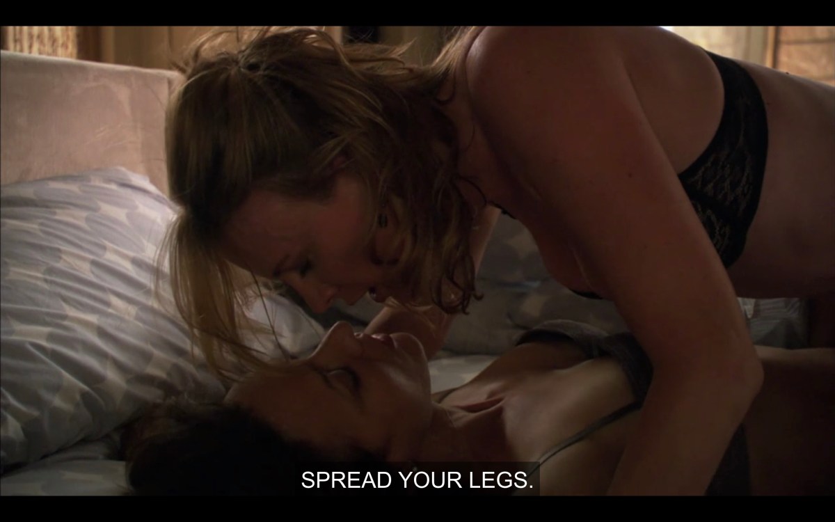 Tina on top of Bette in bed, saying "spread your legs"