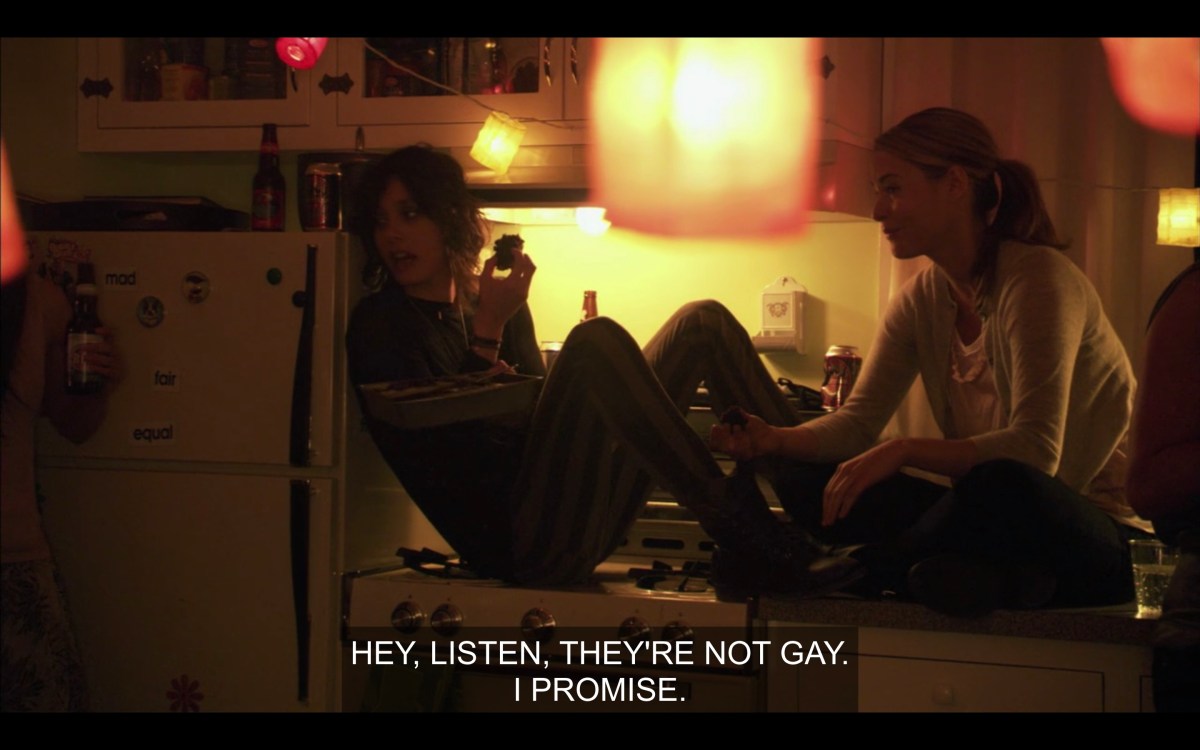 Shane and Alice sitting on the kitchen counter eating brownies, telling someone that the brownies aren't gay
