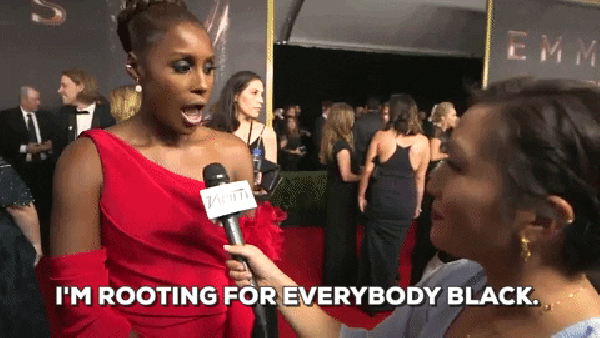 A gif of Issa Rae at the 2017 Emmy Awards. She is wearing a red dress on the carpet and says: "I'm rooting for everybody Black."