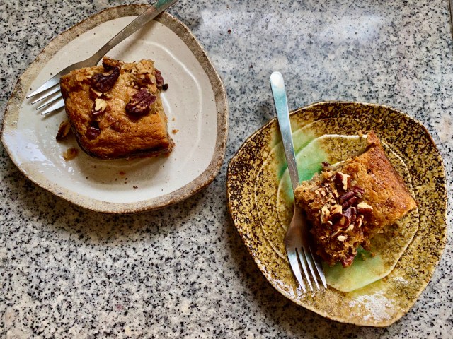 two ceramic plates with rectangles of pecan-covered blondie bars, with small forks sticking off of the sides.