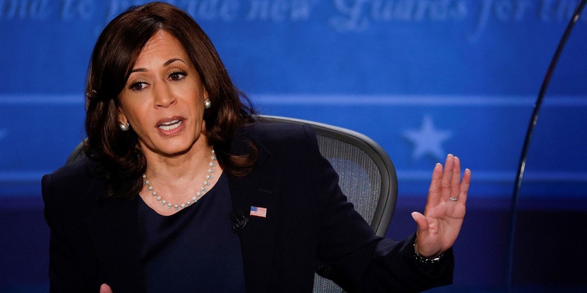 A still frame of Kamala Harris during last night's debate, seated in front of a blue backdrop and mid-sentence as she gestures to the side.