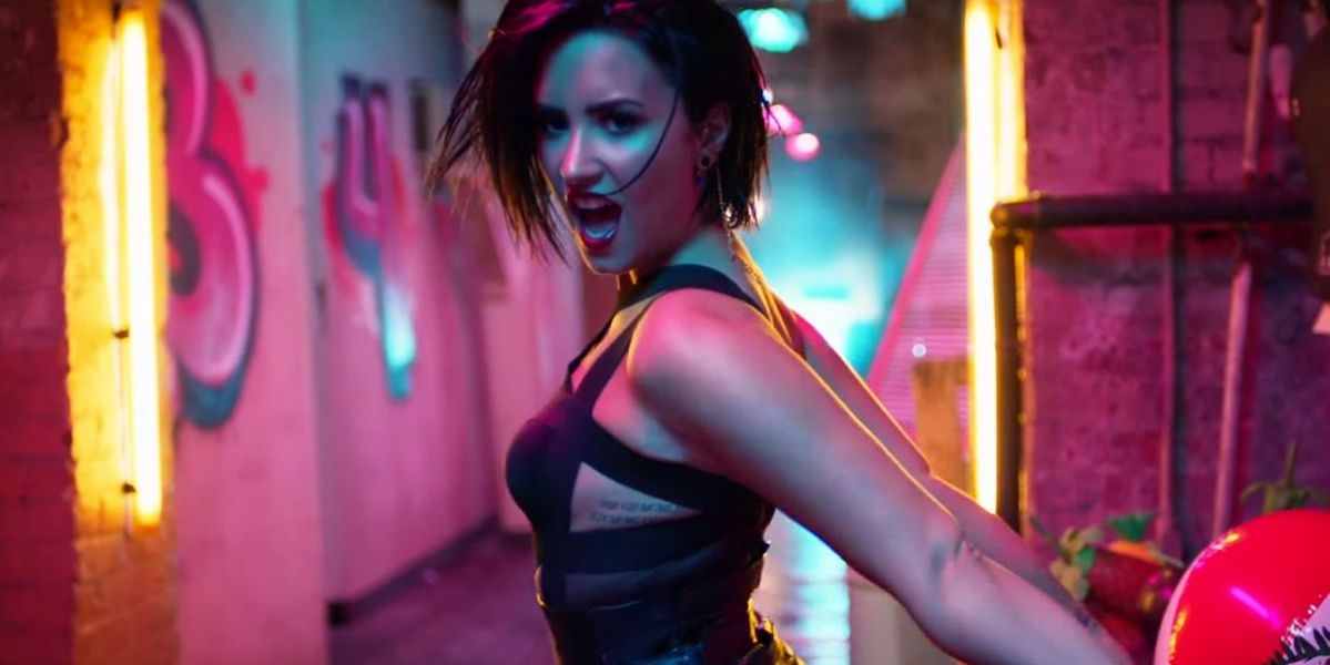 Demi Lovato Pansexual: Demi Lovato in a music video, singing towards the camera in pink and blue lights