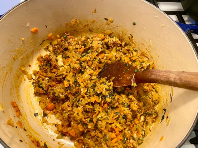 shot into a pot of a bunch of cooked down vegetables and aromatics into a paste-like texture