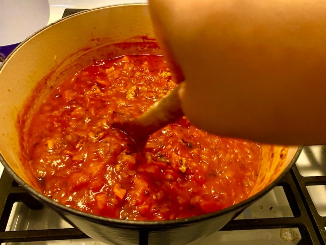 a look into the top of a pot that's filled with a simmering meat sauce