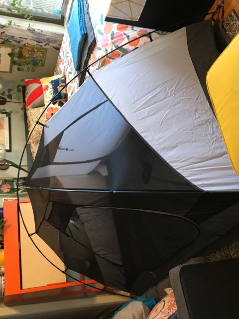 A tent constructed in a cramped living room.