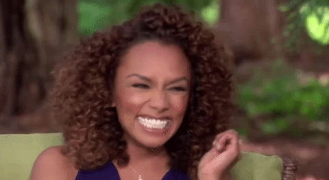 A gif of Janet Mock laughing with a full teeth smile and eyes full of glee.