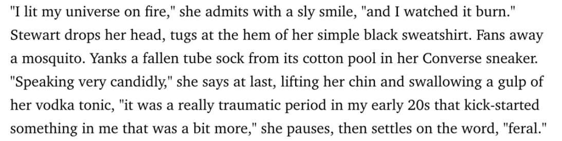 Block of text: "I lit my universe on fire," she admits with a sly smile, "and I watched it burn." Stewart drops her head, tugs at her simple black sweatshirt. Fans away a mosquito. Yanks a fallen tube sock from its cotton pool in her Converse sneakers. "Speaking very candidly," she says at last, lifting her chin and swallowing a gulp of her vodka tonic, "it was a really traumatic period in my early 20s that kickstarted something in me that was a bit more," she pauses, then settles on the word, "feral."