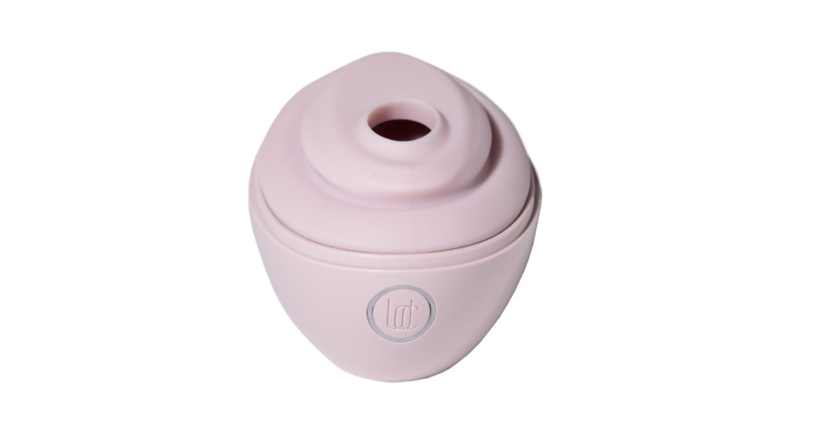 a pink suction toy that looks a little like a short travel cup with the lid on but the drinking hole open, but in a sex toy way