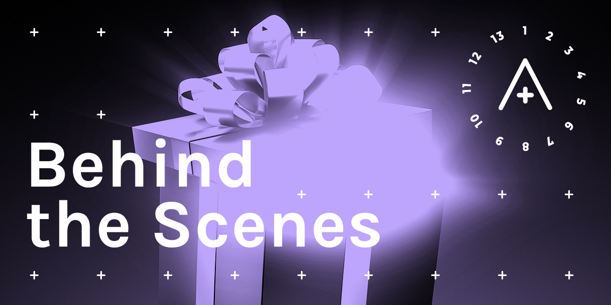 Image reads: Behind the Scenes. A wrapped gift box, lavender against a black background, has a wild, glowing energy coming out of it. The A+ logo is in the upper right.