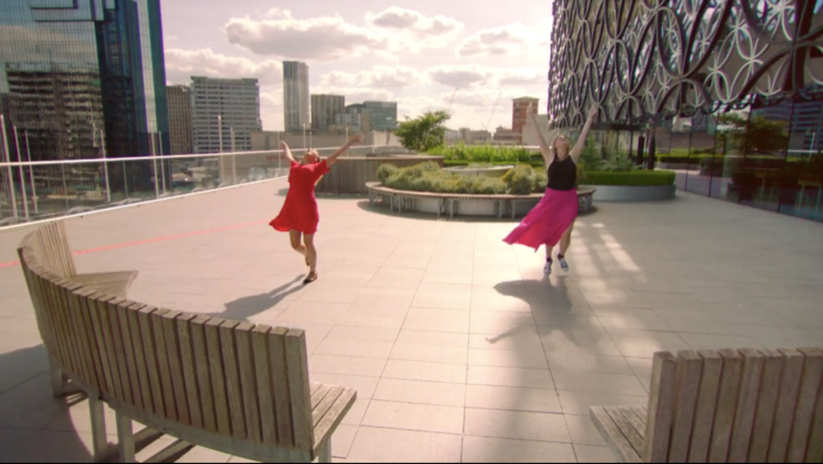 A scene from reality dating show Flirty Dancing where two girls are dancing on a rooftop in late afternoon