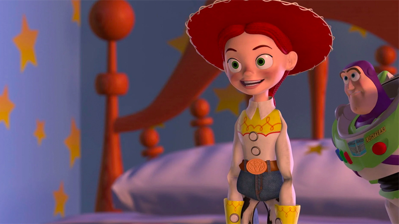 Bisexual Disney character/horse girl Jessie stands on Andy's bed in her cowgirl hat looking excited. She is the only Toy Story toy on the Bisexual Disney Characters list. 