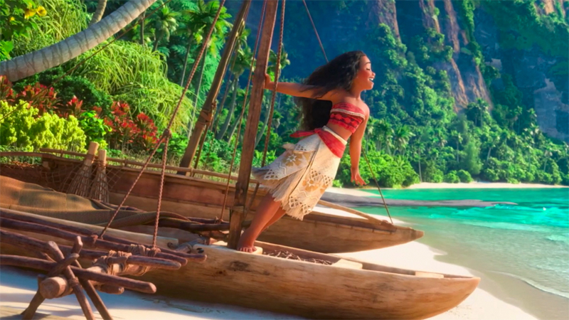 Moana stands on a boat on the shore and sings. 