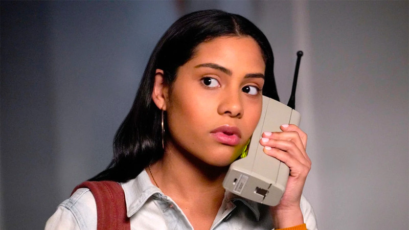 Daisy (Haskiri Velazquez) talks on a huge '90s cell phone.