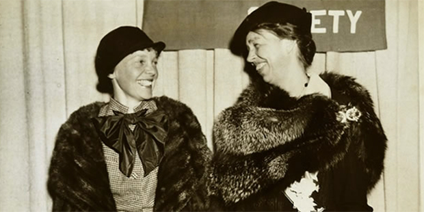 Amelia Earhart and Eleanor Roosevelt stare lovingly at each other and smile in this vintage photograph.