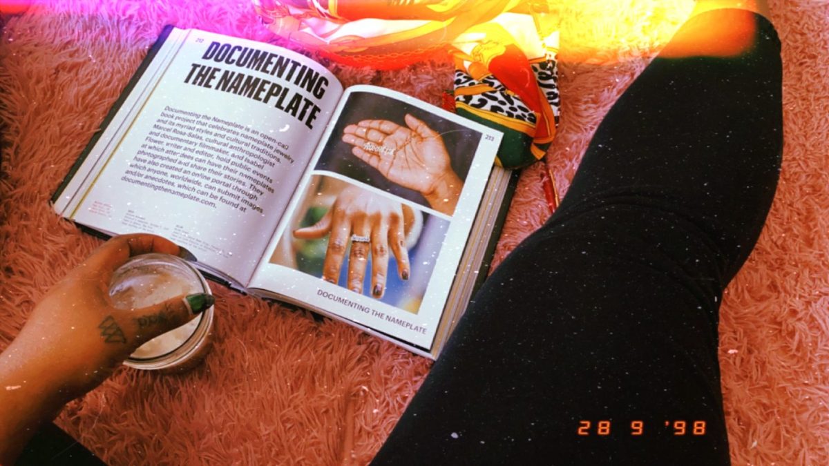 Image shows an excerpt from the book "Black Futures" called "Documenting The Nameplate". There is a person in the frame and we only see their lower body and there is a scarf in the frame and a cup of coffee.