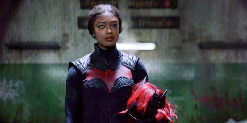 In this review of Batwoman season two, Ryan Wilder is in the Batsuit with her wig and make held in her arms.