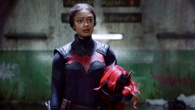 In this Batwoman season two review, Ryan Wilder is in the Batsuit with her wig and make held in her arms.