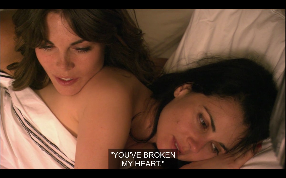 Nikki leaning on Jenny's shoulder in bed, naked, quoting Jenny saying "you've broken my heart"