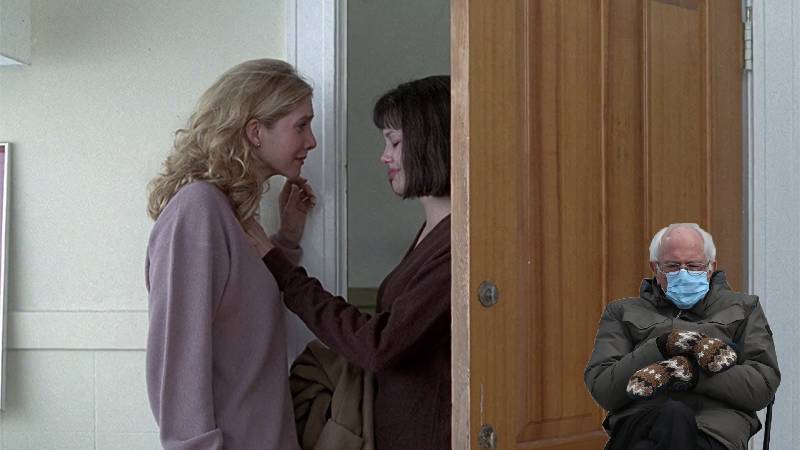 A cut out of Bernie Sanders creeps behind the door while Gia flirts with her girlfriend in the movie Gia