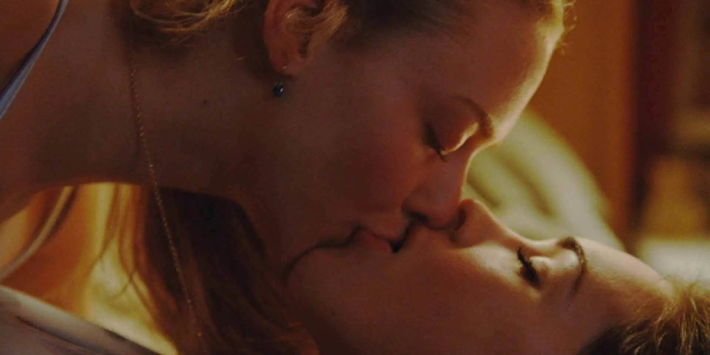 Amanda Seyfried and Megan Fox kiss in bed.