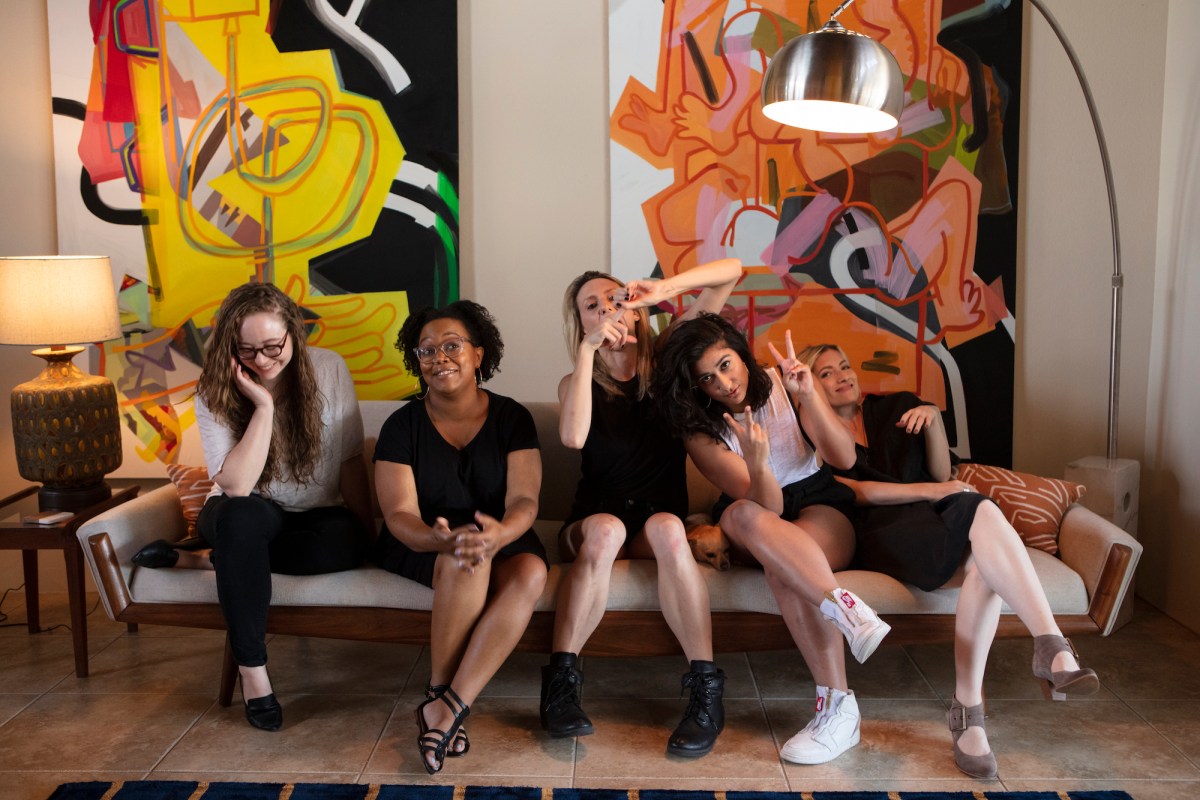 A photo of the Autostraddle Senior Team making funny faces while sitting on the couch: Rachel, Carmen, Riese, Sarah, and Laneia