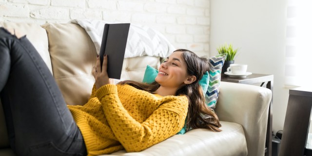 reading on a couch in a sweater