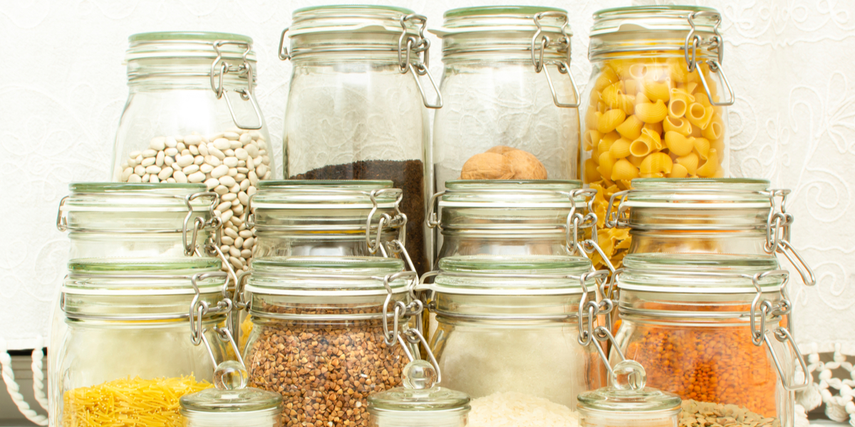 A close up photo of sealed jars packed with dry goods