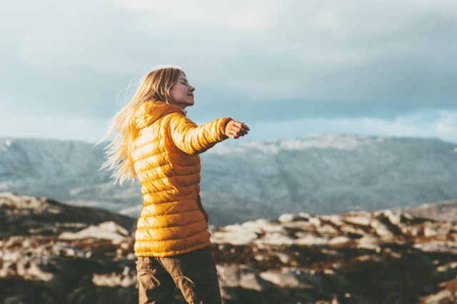 A white femme in a yellow winter coat