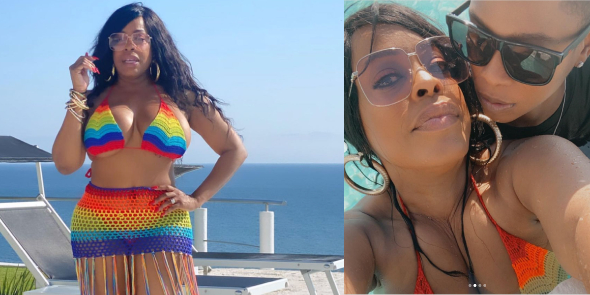 Niecy Nash is in a rainbow bikini with a rainbow beaded skirt. In one photo she is posing against a blue sky, and in the next she is hugged up with her wife, Jessica Betts. They both have on sunglasses.