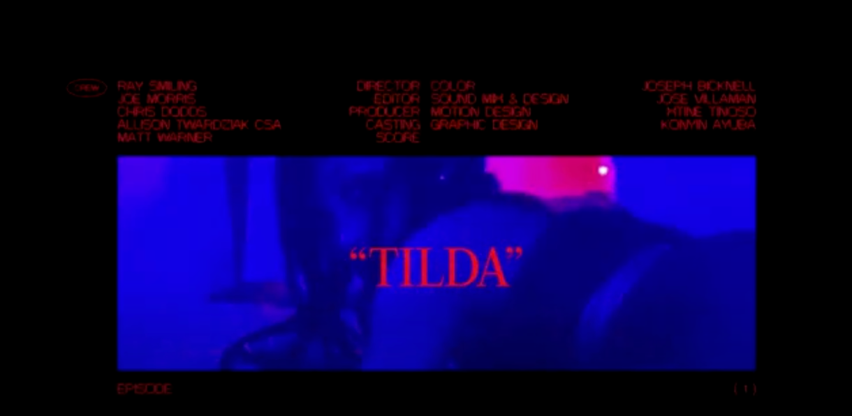 Image shows a dimly lit photo of a black woman clad in black lingerie, the word "TILDA" is placed over her photo with credits of the crew atop.